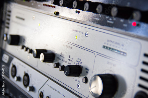 A rack of audio compressors in a recording studio.