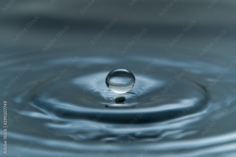 a drop of water hovering in the air before hitting a water surface, which will cause a beautiful splash, close-up photo