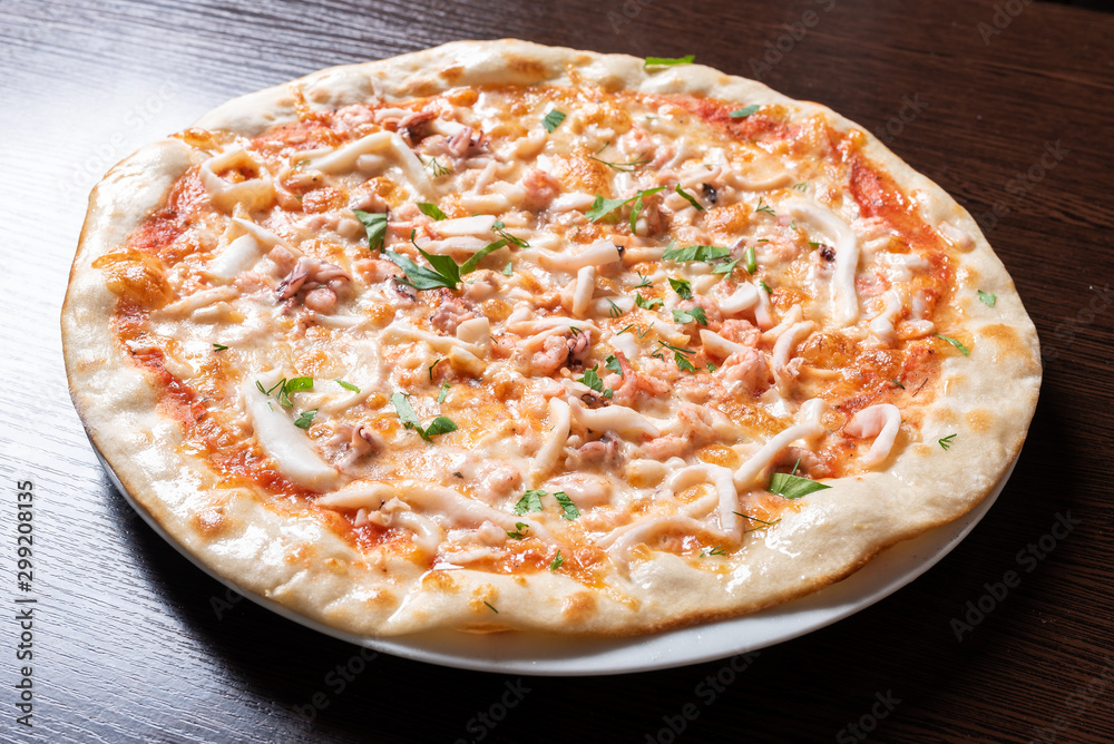Cheap pizza with chicken, squid, herbs.
