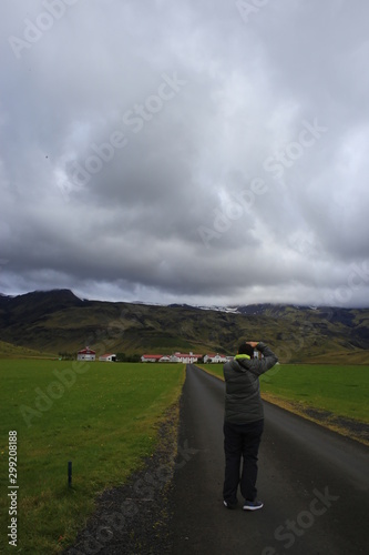 Hombre de espaldas fotografiando paisaje en Islandia