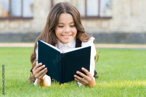 Who needs rest when theres another book to be read. Adorable small child read book on green grass. Cute little girl relax reading book outdoor. Seize every day with new book. School and knowledge