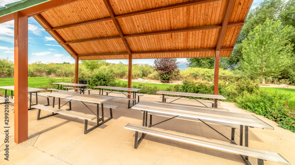 Panorama frame Focus on a pavilion at a park with tables and benches under the green roof