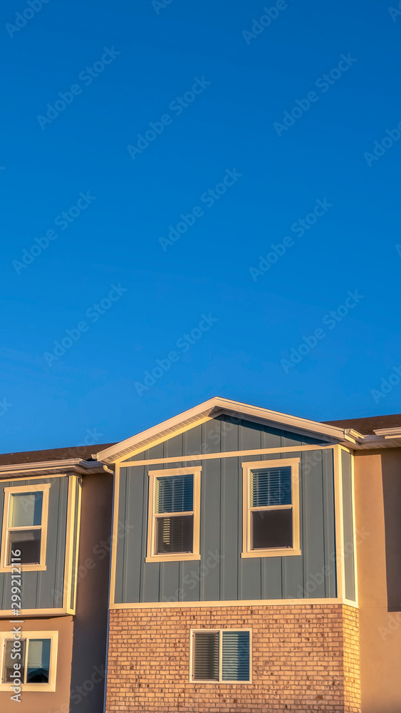 Vertical frame Focus on the upper storey of townhomes with blue sky background on a sunny day
