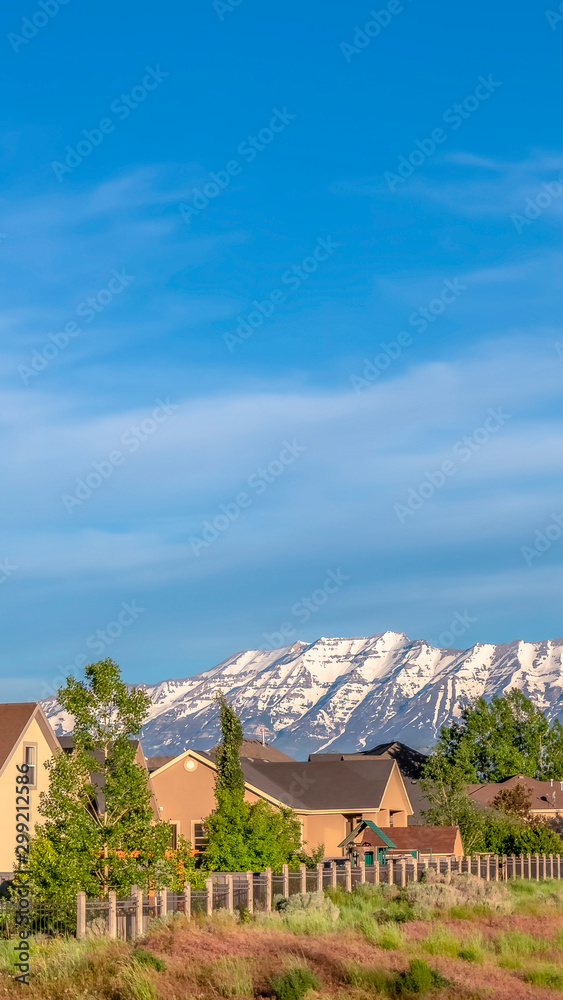 Vertical frame Houses on a hill overlooking a magnificent distant mountain capped with snow
