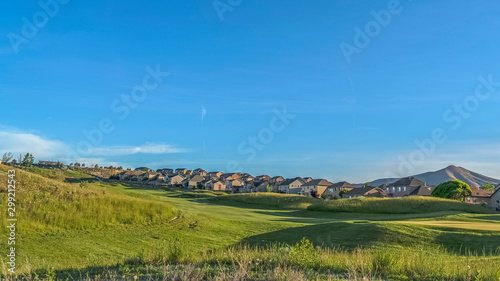 Panorama frame Grass covered golf course with homes in the background viewed on a sunny day