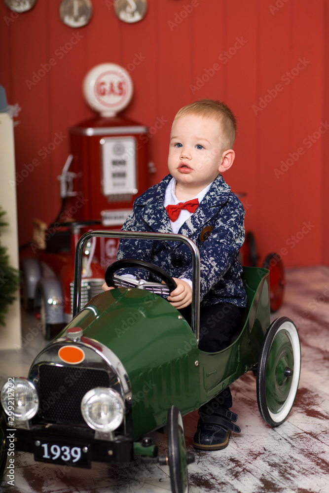 Cute toddler is playing with toy cars. Rides a toy typewriter airplane. Happy childhood Cute toddler is playing with toy cars. Rides a toy typewriter airplane. Happy childhood