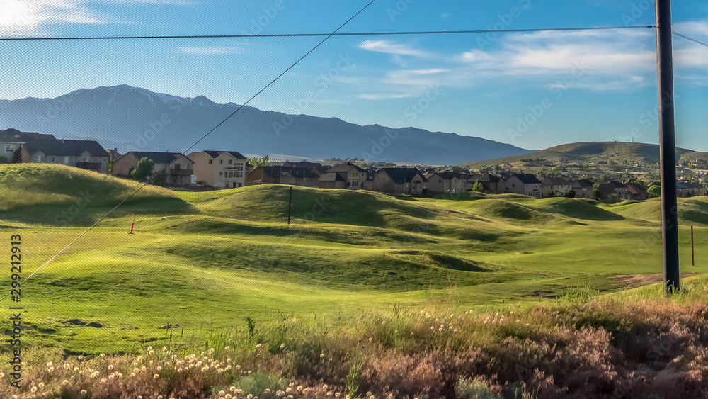 Panorama Fence with golf course homes and mountain against blue sky on the other side Panorama Fence with golf course homes and mountain against blue sky on the other side