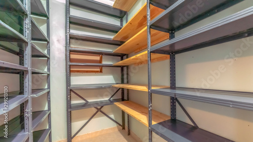 Panorama frame Interior of a small empty closet with metal and wood shelves for clothes