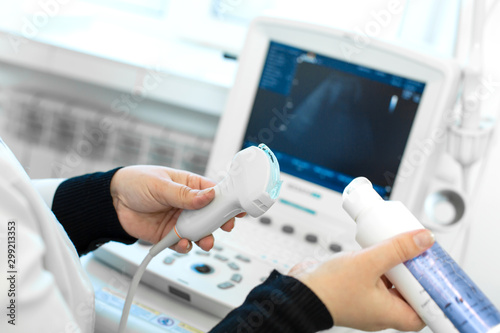 Doctor prepare an ultrasound machine for the diagnosis of a patient. Doctor puts media gel on an ultrasound transducer photo