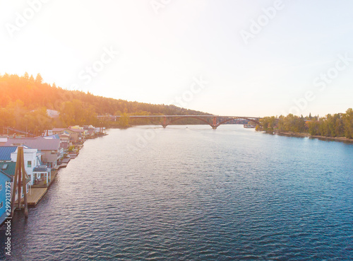 A pier with houses on the water in the USA at sunset in autumn, shot from above using a drone