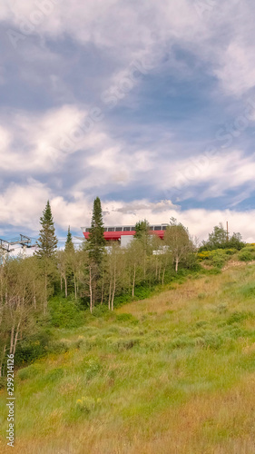 Vertical frame Cloudy blue sky over mountain and chairlifts in Park City Utah suring off season © Jason