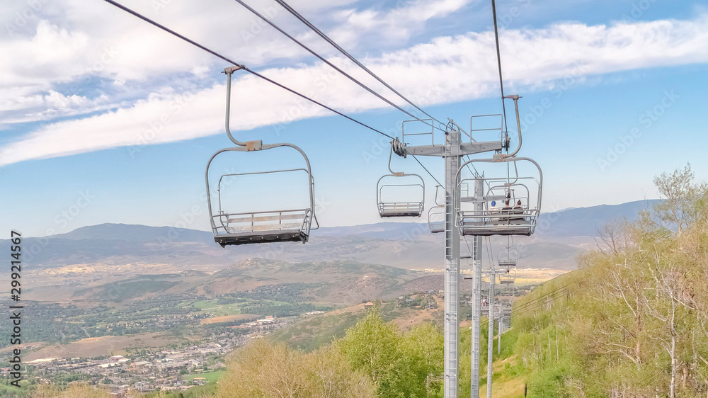 Panorama frame Park City during summer with chairlifts overlooking trees and mountain