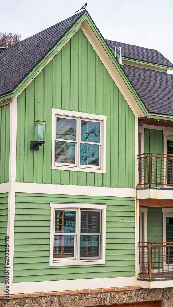 Vertical Townhouses with green exterior wall and small balconies viewed in winter Vertical Townhouses with green exterior wall and small balconies viewed in winter
