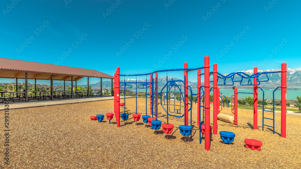 Panorama Climbing bars and steps playground equipment at a park against lake and mountain Panorama Climbing bars and steps playground equipment at a park against lake and mountain