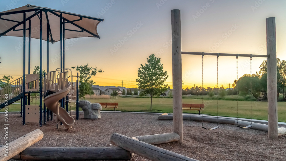 Panorama frame Neighborhood park with fun playground featuring slides and swings for children Panorama frame Neighborhood park with fun playground featuring slides and swings for children