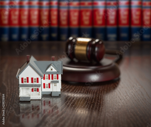 Gavel and Small Model House on Wooden Table. photo