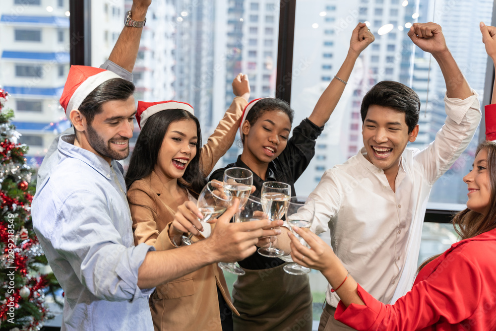Fototapeta premium office christmas party. Merry Christmas and Happy New Year Multiracial young creative people are celebrating holiday in modern office. Group of young business people are drinking champagne