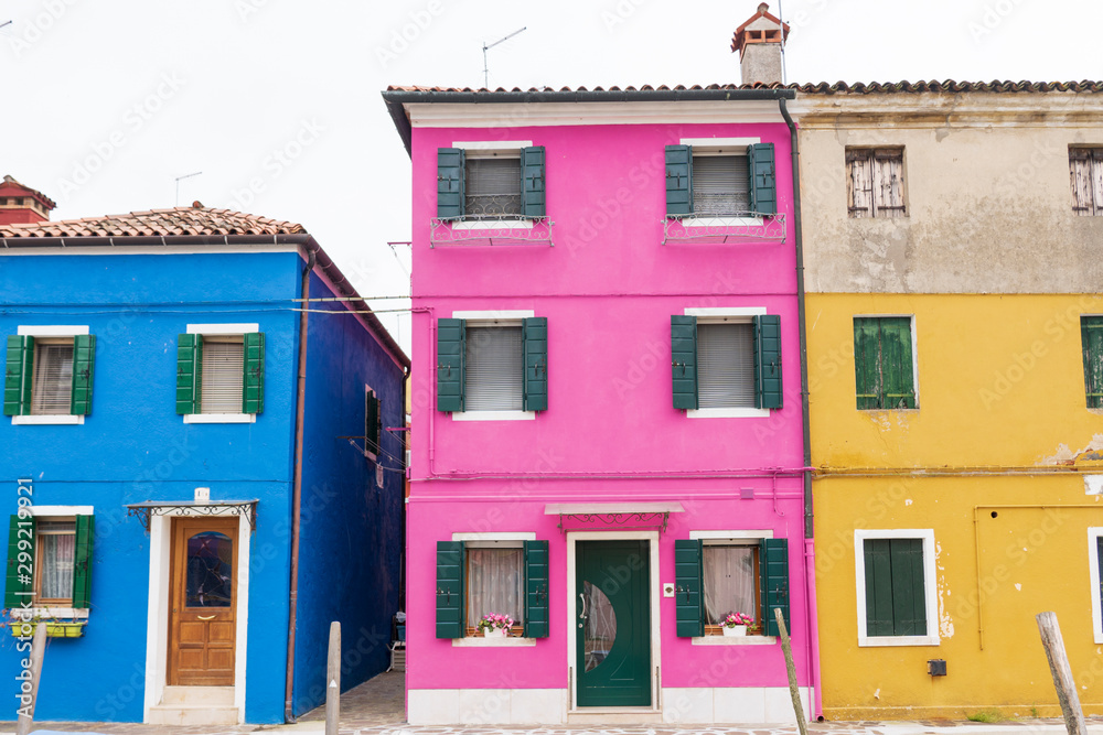 Burano, Venice, Italy - May 21, 2019: Colorful painted residential houses in Burano island, Venice, Italy. Burano street with ?olorful facade building. Colorful architecture in Burano island.