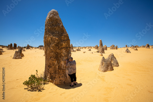 Landscape view of mature woman tourist admiring the limestone pinnacles in the Nambung National Park, Cervantes, Western Australia.