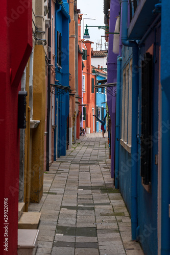 Burano, Venice, Italy - May 21, 2019: Colorful painted residential houses in Burano island, Venice, Italy. Burano street with ?olorful facade building. Colorful architecture in Burano island.
