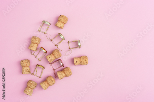 Christmas and New Year holiday greeting card with champagne corks and muselets on pink paper. Concept of celebration. Flat lay. Top View.