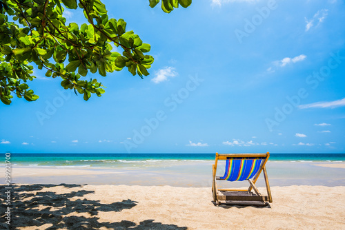 Fototapeta Naklejka Na Ścianę i Meble -  Tropical tree and beach chair at white sand beach and blue sea