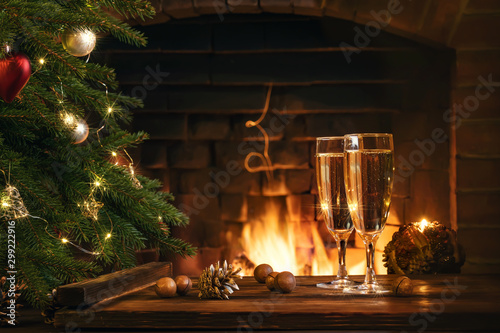 Obraz na plátně Christmas composition - Two glasses with champagne on a wooden table near a Chri
