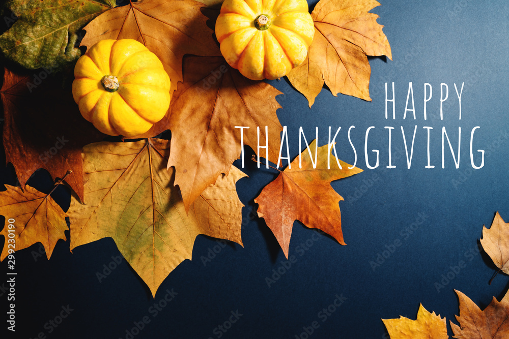 Happy Thanksgiving Day with maple leaves and pumpkin on blue background Happy Thanksgiving Day with maple leaves and pumpkin on blue background
