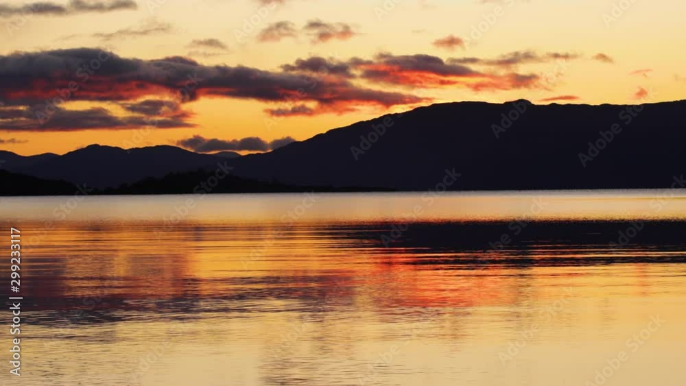 golden light at sunset reflecting on a scottish loch in the argyll region of the highlands of scotland in autumn golden light at sunset reflecting on a scottish loch in the argyll region of the highlands of scotland in autumn