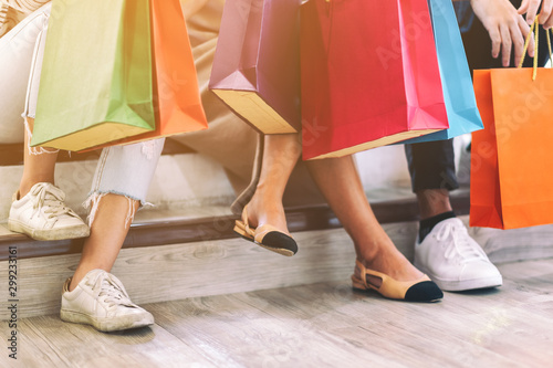 Closeup image of people holding shopping bags while sitting together