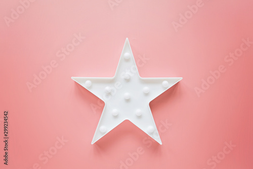 Star shaped white LED lights lamp single frame. Creative conceptual top view flat lay composition with copy space on pink background in minimal style. Overhead  template  mockup