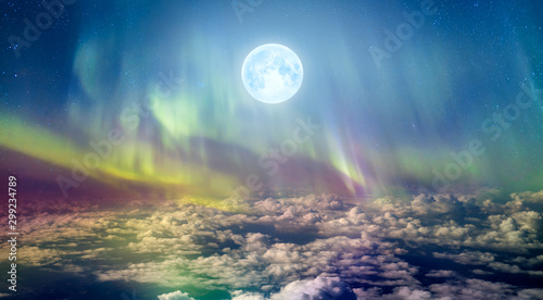 Northern lights (Aurora borealis) in the sky over clouds with full moon "Elements of this image furnished by NASA"