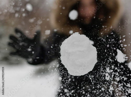 Obraz na plátně The girl throws a snowball at the camera