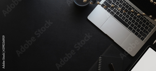 Top view of dark modern workspace wit laptop computer and copy space with office supplies