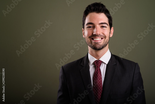 Face of happy young handsome businessman in suit smiling