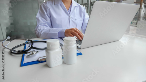 A female doctor sitting at work examines the patient s history and uses a laptop to record patient information at the hospital. Medical concepts and attention