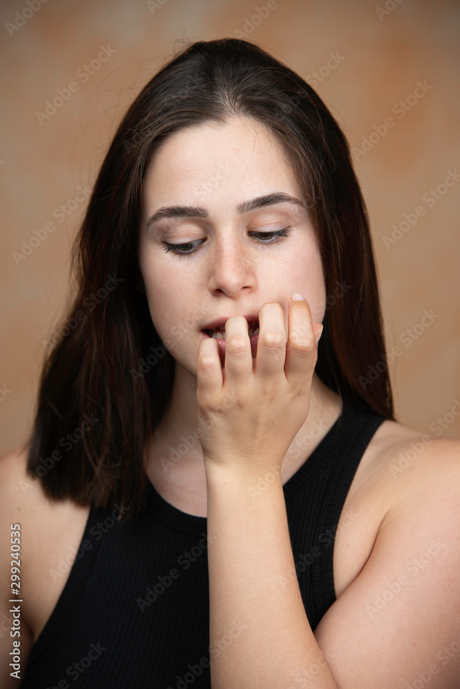 Portrait of pretty brunette lady biting nails Portrait of pretty brunette lady biting nails