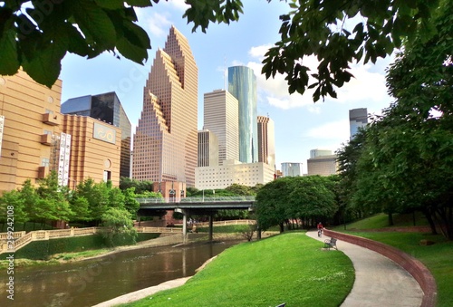 Bicyclist on Paved Bike Path in Buffalo Bayou Park, with the Skyline of Downtown Houston in the Background - Houston, Texas, USA photo