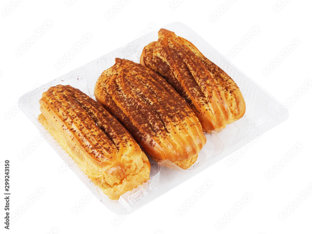 Three custard eclairs with cacao powder in a plastic container isolated on white background Three custard eclairs with cacao powder in a plastic container isolated on white background
