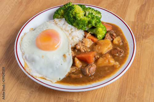 Chicken curry Rice on wooden background ( Poached egg, Potato, enoki mushroom, onion, broccoli, Japanese style,)