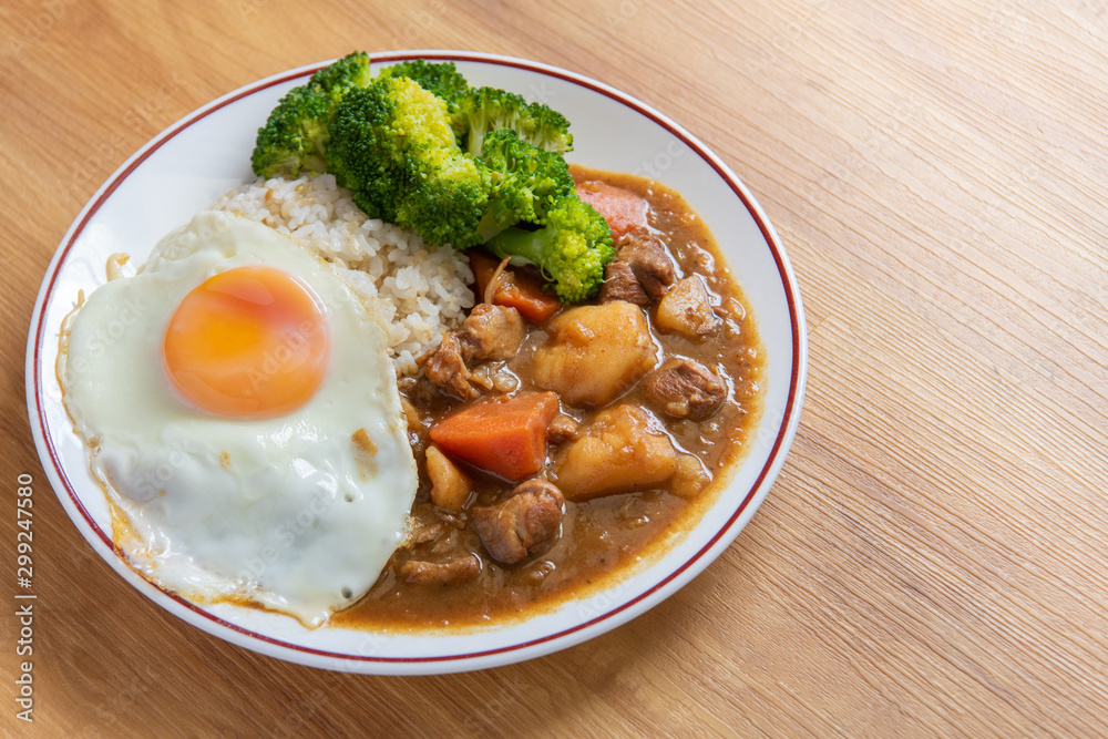 Chicken curry Rice on wooden background ( Poached egg, Potato, enoki mushroom, onion, broccoli, Japanese style,)