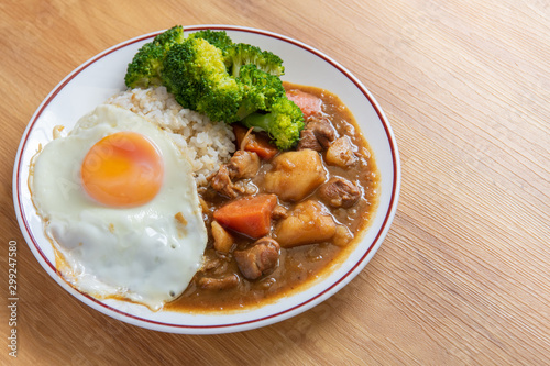 Chicken curry Rice on wooden background ( Poached egg, Potato, enoki mushroom, onion, broccoli, Japanese style,)
