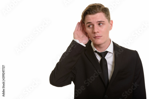 Young handsome blonde businessman in suit listening