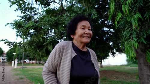 slow-motion of senior woman walking with walking stick in the park photo