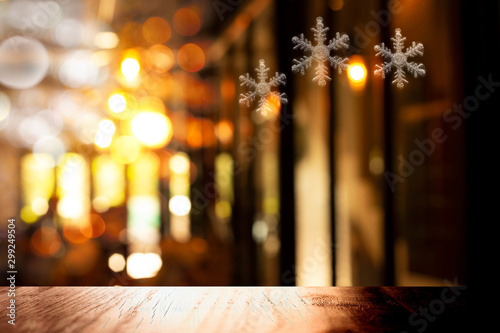top of black wood table with Christmas snowflake symbol in light of pub or bar party dark night background