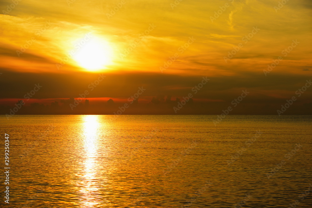 The view of the golden sky, the sea and a small fishing boat in the early morning, the sun is rising.