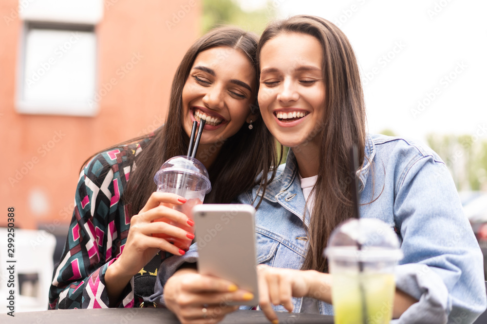 Young girls friends watch something in smartphone. Young girls friends watch something in smartphone.