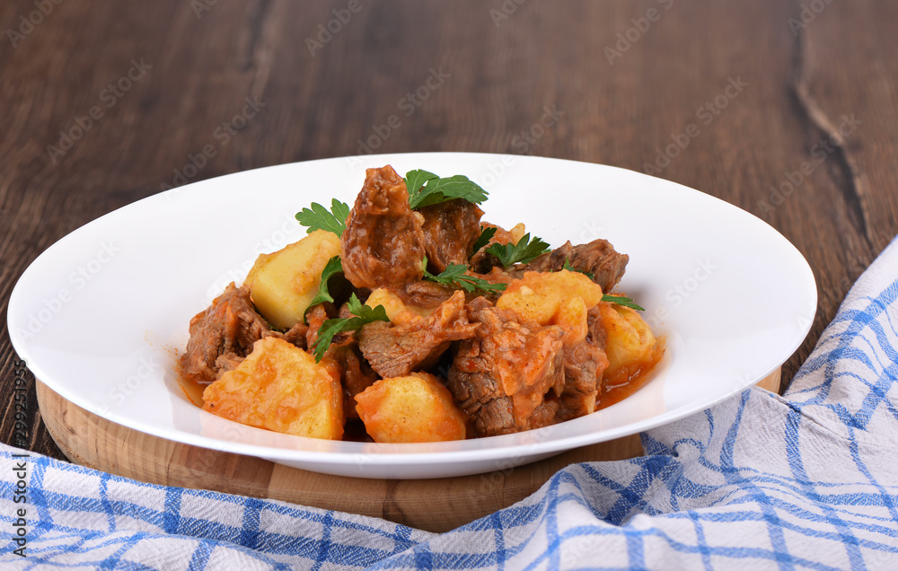 Beef stew with potatoes in a white plate. Beef stew with potatoes in a white plate.