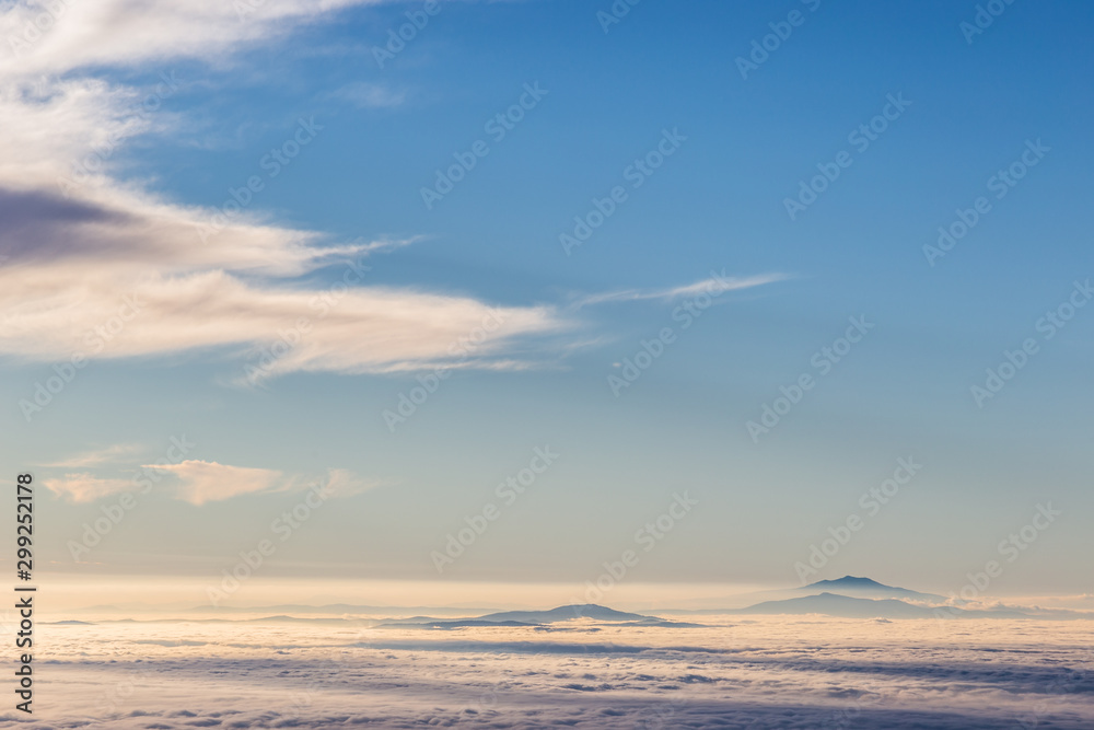 Distant mountains above a sea of fog like islands at sunset Distant mountains above a sea of fog like islands at sunset