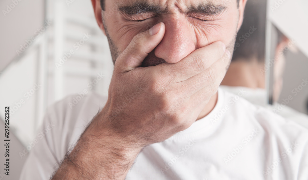 Fototapeta premium Caucasian man suffering toothache in bathroom.